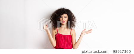 Annoyed caucasian woman in red dress, showing finger without wedding ring, arguing about marriage, standing pissed-off on white background Annoyed caucasian woman in red dress, showing finger without wedding ring, arguing about marriage, standing pissed-off on white background 98917360