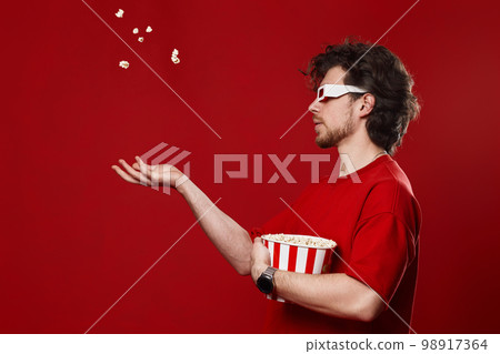 man in 3d glasses, red t-shirt throwing up and eating popcorn man in 3d glasses, red t-shirt throwing up and eating popcorn 98917364