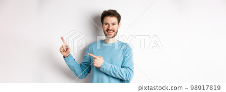 Happy bearded man showing advertisement, pointing fingers right and smiling, inviting to click link, standing over white background Happy bearded man showing advertisement, pointing fingers right and smiling, inviting to click link, standing over white background 98917819