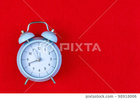 Blue retro alarm clock on red background with copy space. Concept of time, 5 minutes to 12, until the New year 98918006