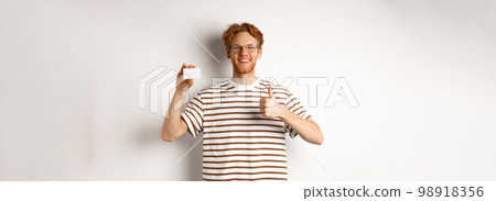 Shopping and finance concept. Satisfied male bank client showing thumbs-up and plastic credit card, smiling happy at camera Shopping and finance concept. Satisfied male bank client showing thumbs-up and plastic credit card, smiling happy at camera 98918356