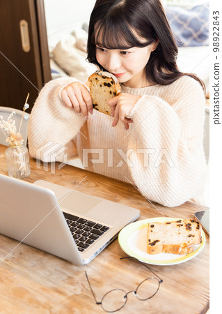 College student enjoying videos on laptop 98922843