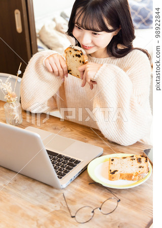 College student enjoying videos on laptop 98922844