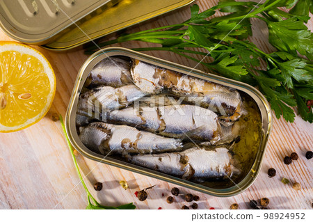 Open can of sardines on table 98924952