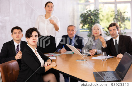 Young Hispanic businesswoman listening to presentation of partners Young Hispanic businesswoman listening to presentation of partners 98925343