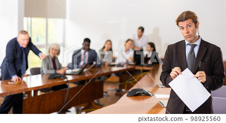 Guilty businesswoman in a meeting room against background of disgruntled colleagues Guilty businesswoman in a meeting room against background of disgruntled colleagues 98925560