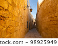 Mdina, Malta - 12 15 22: sandstone walls of narrow Mdina street 98925949