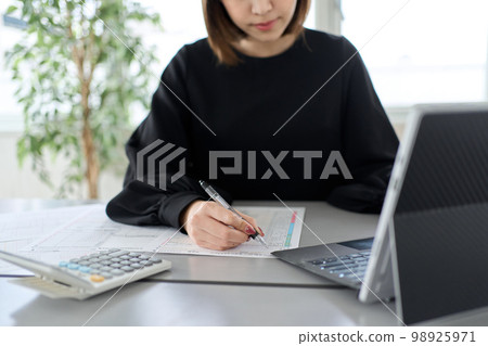 Asian woman preparing tax return documents 98925971