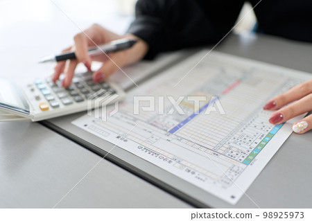 Asian woman preparing tax return documents 98925973