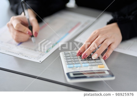 Asian woman preparing tax return documents 98925976