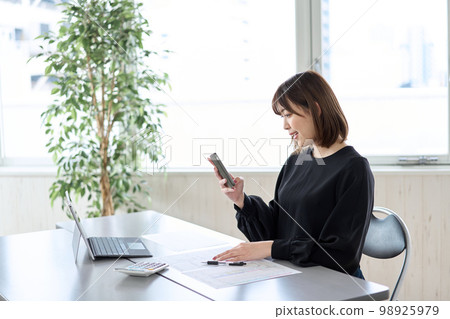 Asian woman filing tax return on smartphone Asian woman filing tax return on smartphone 98925979