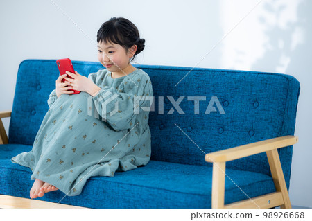 Elementary school girl looking at smartphone Elementary school girl looking at smartphone 98926668