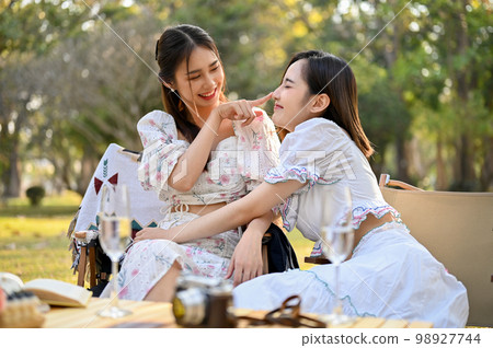 Two beautiful Asian female besties cuddle, playing, sharing a special moment together 98927744
