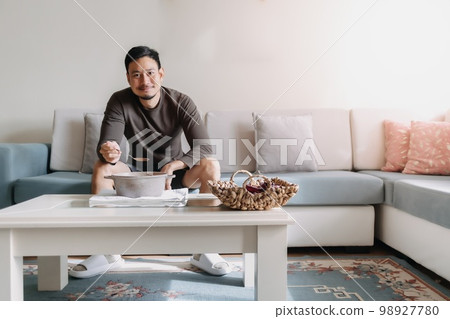 Lonely man having a meal alone in his home. 98927780