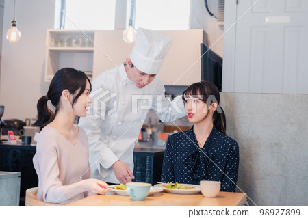 Chef explaining the menu to customers 98927899