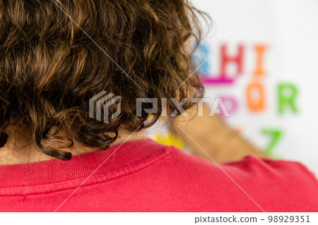 Over the shoulder shot of person looking at alphabet magnets Over the shoulder shot of person looking at alphabet magnets 98929351