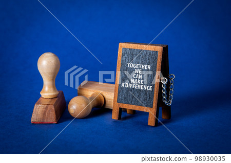 Together We Can Make A Difference. Miniature chalkboard on a blue background Together We Can Make A Difference. Miniature chalkboard on a blue background 98930035