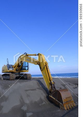 Excavator at a coastal erosion control construction site 98930668