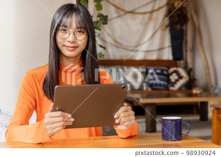 Woman enjoying videos on her tablet 98930924