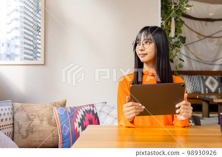 Woman enjoying videos on her tablet 98930926