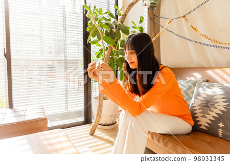 Woman enjoying videos on her smartphone 98931345