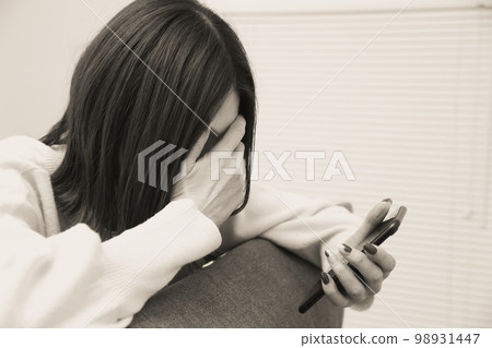 手拿智能手機的沮喪的婦女 手拿智能手機的沮喪的婦女 98931447