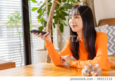 Young woman watching TV away from TV 98931518