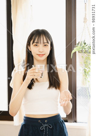 young woman taking supplements 98931731
