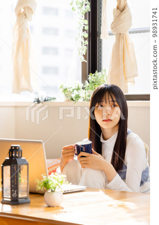 Young woman watching video on laptop 98931741
