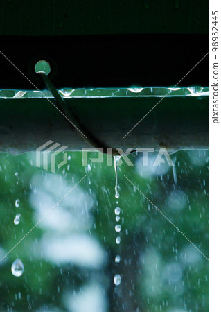 The weather is rainy, drops of rainwater dripping from the roof 98932445