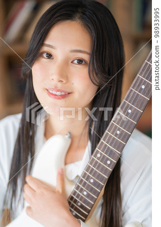 Young woman portrait (electric guitar) Young woman portrait (electric guitar) 98933995