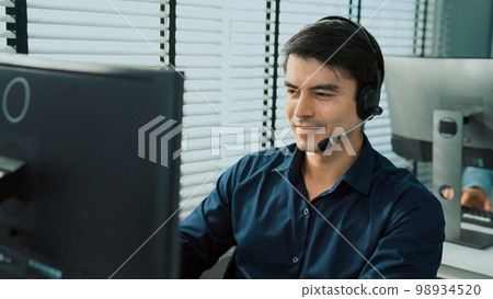 Young competent asian male call center agent working in the office. 98934520