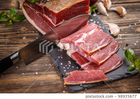 Prosciutto sliced on black slate 98935677