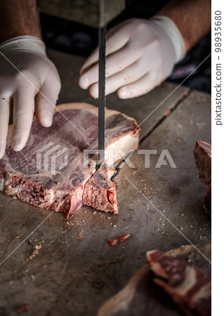Butcher is slicing meat 98935680