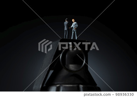 A miniature doll shaking hands with a toy grenade A miniature doll shaking hands with a toy grenade 98936330