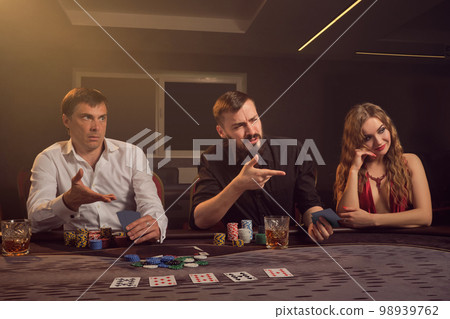 Group of a young wealthy friends are playing poker at a casino. 98939762