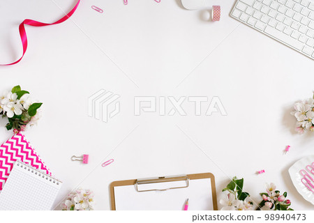 On a white flat lay background with apple flowers keyboard and stationery clips, a female floral desktop. The concept of a stylish spring morning. top view and copy space 98940473