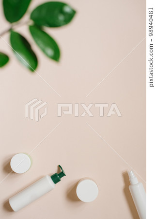 Organic herbal cosmetics in bottles and cans on a beige background with tropical leaves Organic herbal cosmetics in bottles and cans on a beige background with tropical leaves 98940481