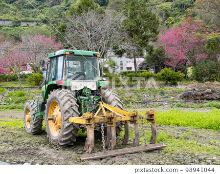 Modern tractor in the agricultural field. 98941044