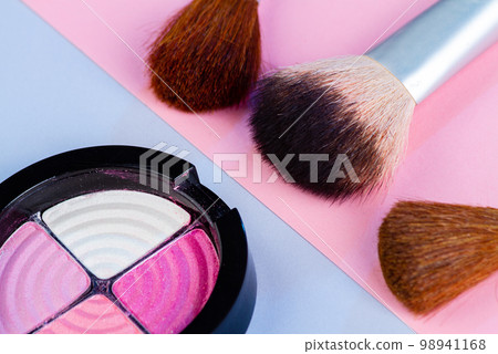 Close up of round eyeshadow palette with brushes. Cosmetic makeup accessories. 98941168
