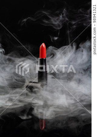 Red lipstick with steam on black background. Vertical shot close up. 98941321