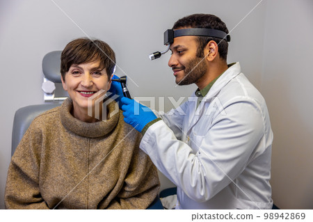 Senior woman having hearing checkup at ent doctor 98942869