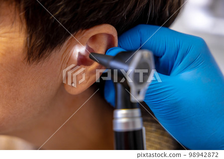 ENT doctor examining an elderly female patient 98942872