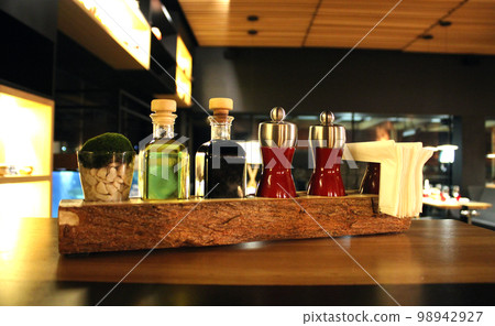 Glass Bottles With Oil, Vinegar, And Spice Garlic On A Restaurant Table Glass Bottles With Oil, Vinegar, And Spice Garlic On A Restaurant Table 98942927