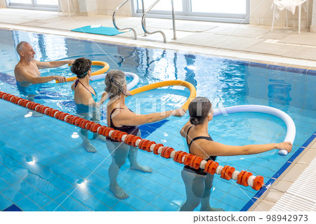 Group of seniors having a workout at the swimming pool 98942973