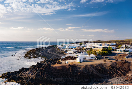 View of El Golfo village and blue ocean on coast of Lanzarote island, Spain View of El Golfo village and blue ocean on coast of Lanzarote island, Spain 98942983