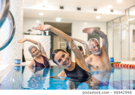 Senior adults in the swimming pool during aqua aerobics class Senior adults in the swimming pool during aqua aerobics class 98942998
