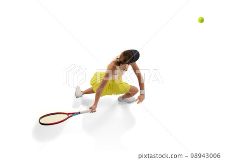 Aerial view of female professional tennis player doing powerful serving in tennis isolated over white background. Sport, fashion, power, energy, ad concept 98943006