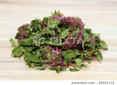 Heap of dried monarda, lat. Monarda didyma, smelling like bergamot., on wooden table Heap of dried monarda, lat. Monarda didyma, smelling like bergamot., on wooden table 98943118
