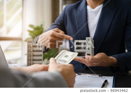 Real estate broker agent presenting and consult to customer to decision making sign insurance form agreement, home model, concerning mortgage loan offer. Real estate broker agent presenting and consult to customer to decision making sign insurance form agreement, home model, concerning mortgage loan offer. 98943462